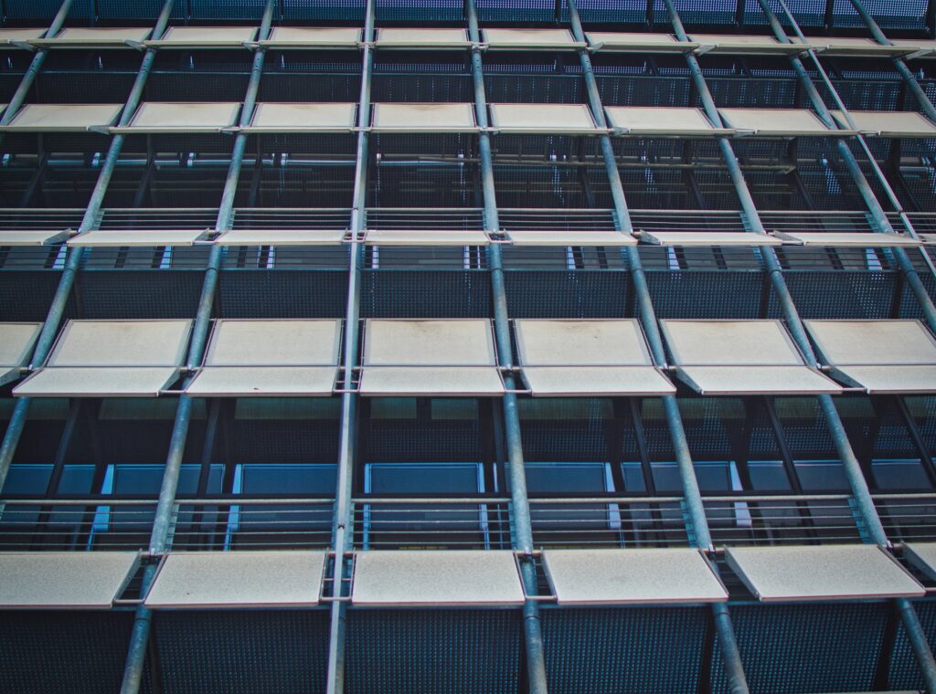 Gebäudefassade mit großen Fensterflächen und Sonnenschutz